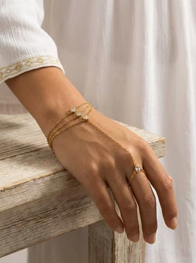 Detalle de circonitas engastadas en pulsera de mano con triple cadena y circonitas