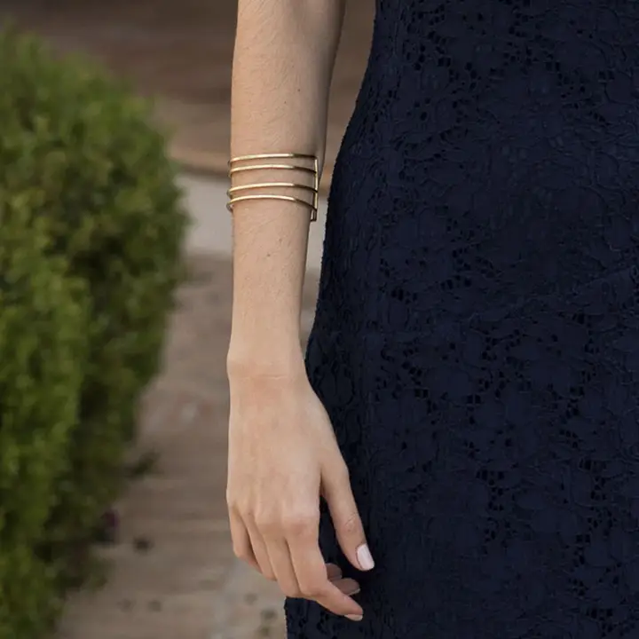 Look de invitada con brazalete rígido de hileras doradas